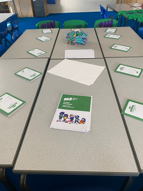Classroom set up for an M2 session with journals and the coach's handbook